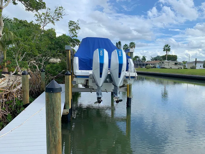  Yacht Photos Pics Hussar Skamander 920 Explorer MAX 2022 boat docked with twin engines, covered, on a calm waterway.