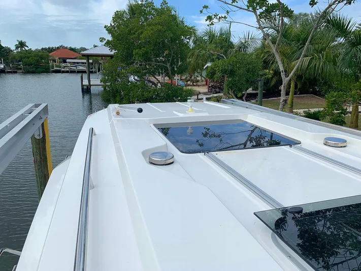  Yacht Photos Pics Hussar Skamander 920 Explorer MAX 2022 boat docked near lush greenery and calm waters.