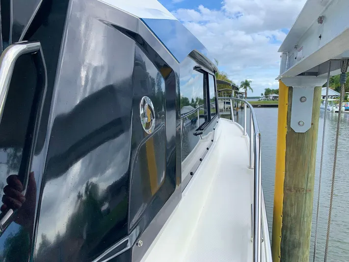  Yacht Photos Pics 2022 Hussar Skamander 920 Explorer MAX boat docked by a scenic waterfront.