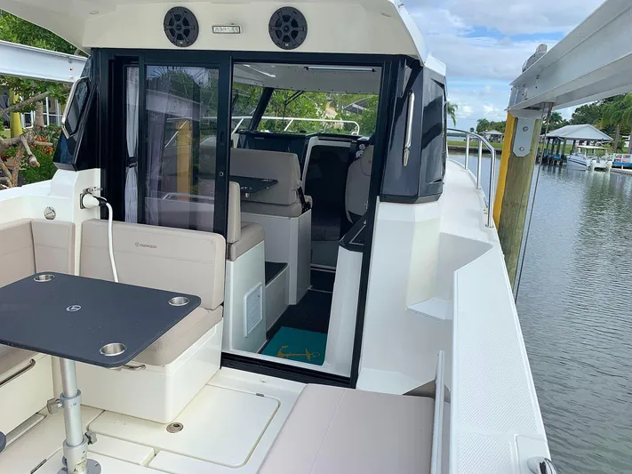  Yacht Photos Pics Hussar Skamander 920 Explorer MAX 2022 boat interior with seating and table, docked by water.