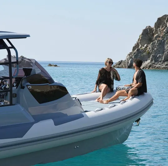  Yacht Photos Pics Couple relaxing on a 2025 Ranieri Cayman 33 Executive boat in clear blue waters.