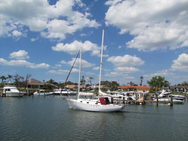 1974 Custom Lazy Jack 32 sailboat docked in a sunny marina with blue skies.