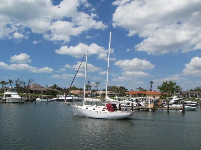 1974 Custom Lazy Jack 32 sailboat docked in a sunny marina with blue skies.