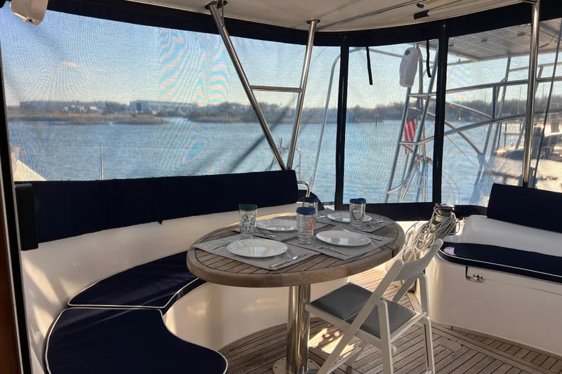 Evolution Yacht Photos Pics Luxury yacht Privilege 495 interior with dining setup, overlooking serene waters.