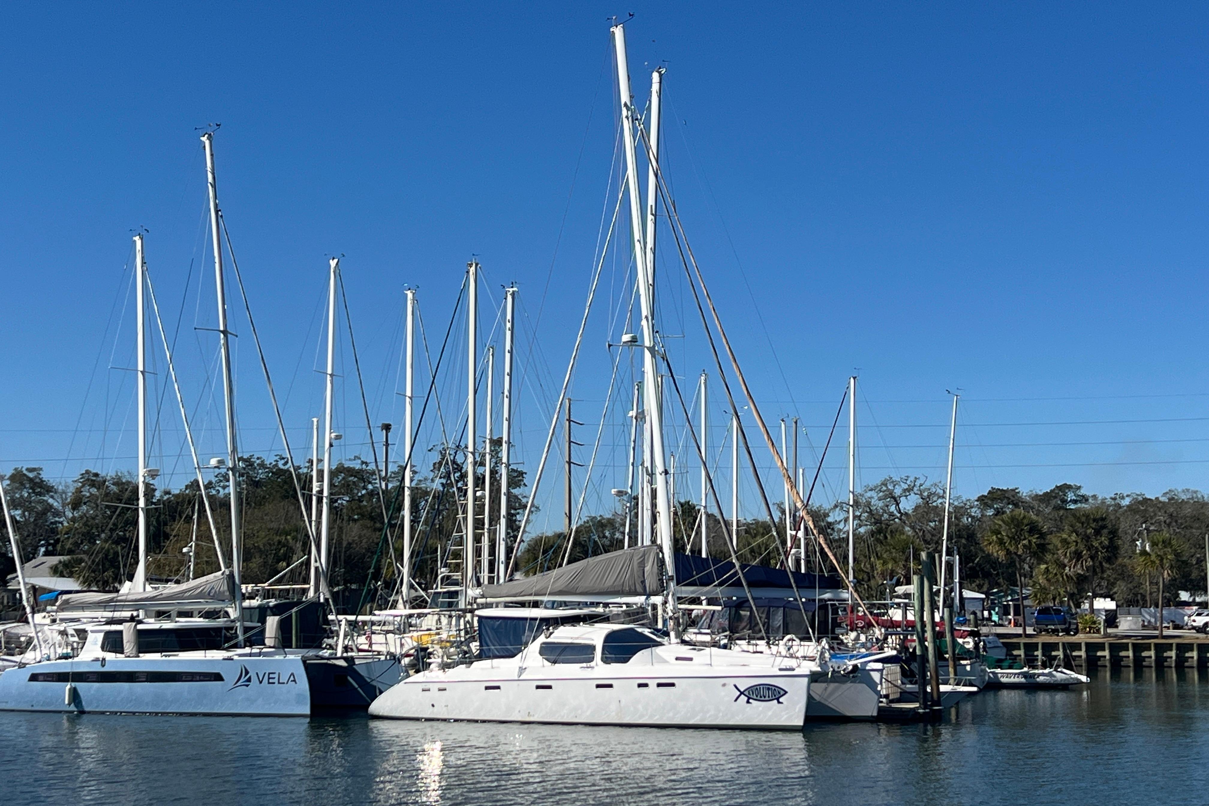 Sailboats docked at a marina, featuring a 2011 Privilege 495 catamaran.