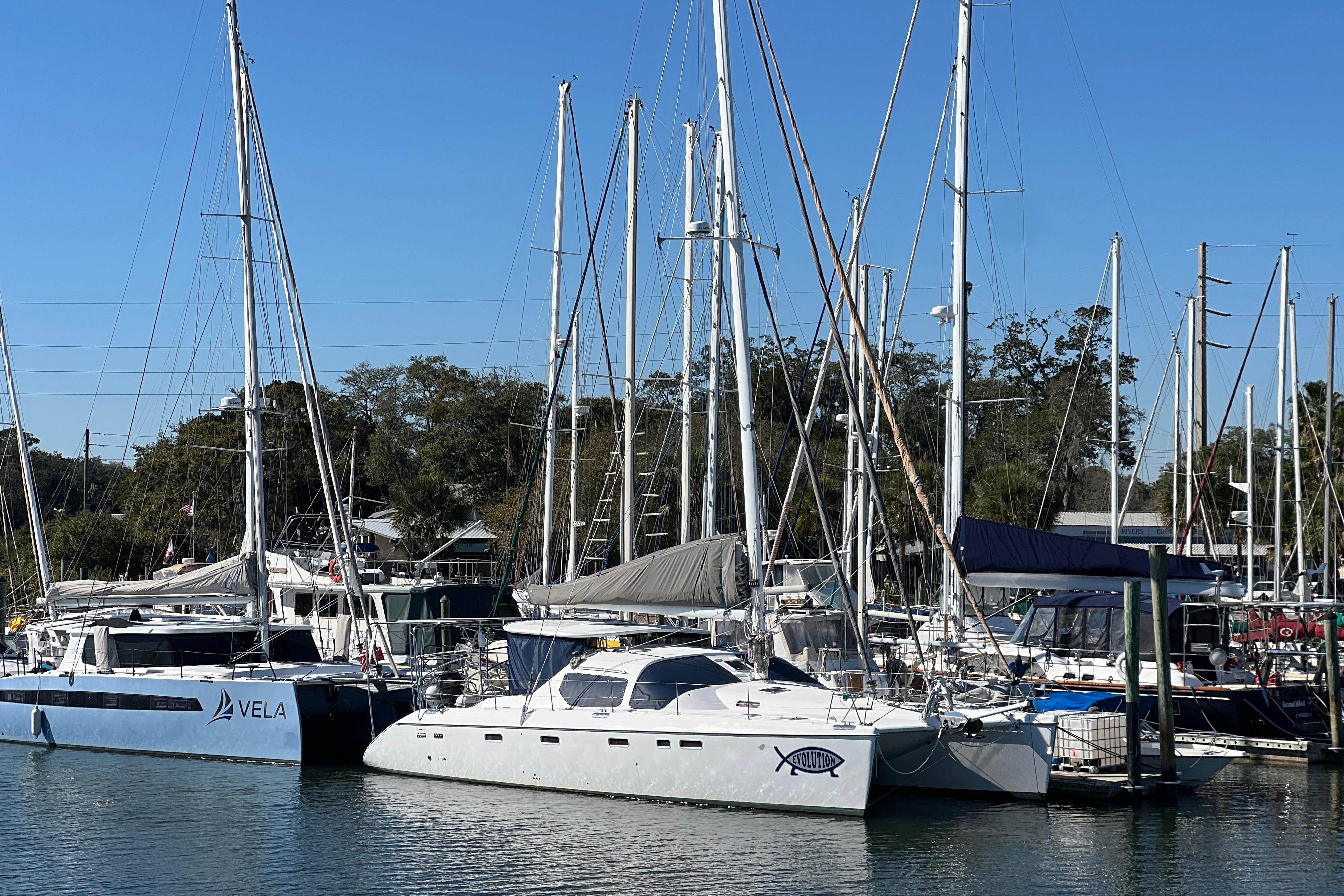 Sailboats docked at a marina, featuring a 2011 Privilege 495 catamaran.