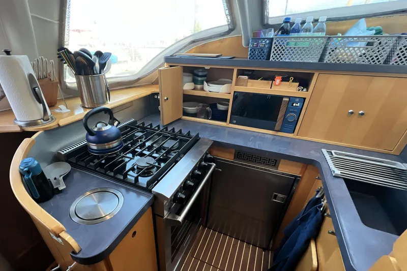 Evolution Yacht Photos Pics Compact kitchen in 2011 Privilege 495 yacht with stove, microwave, and storage.