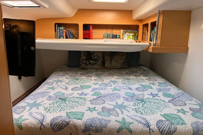 Evolution Yacht Photos Pics Cozy cabin bedroom in 2011 Privilege 495 yacht with nautical-themed bedding and bookshelf.