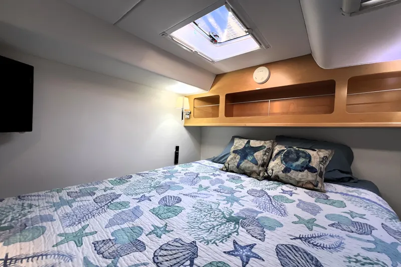 Evolution Yacht Photos Pics Cozy cabin bedroom in 2011 Privilege 495 yacht with nautical-themed bedding and skylight.