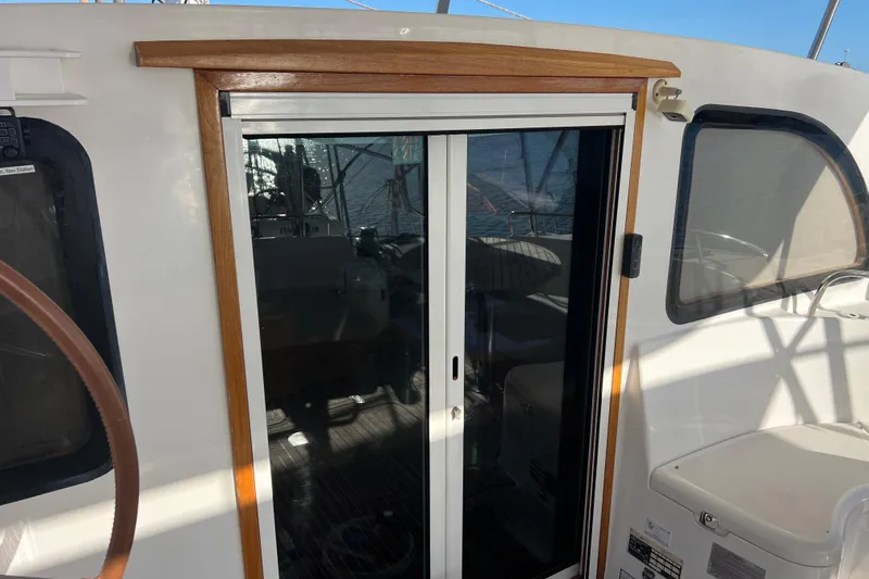 Evolution Yacht Photos Pics Sliding door on 2011 Privilege 495 yacht, featuring wooden trim and ocean reflection.