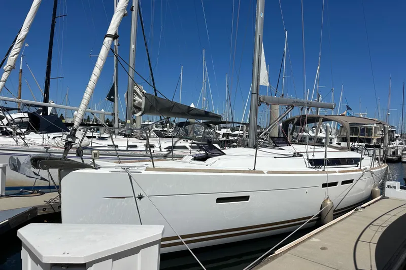 Jenni Yacht Photos Pics 2015 Jeanneau Sun Odyssey 409 sailboat docked at marina under clear blue sky.