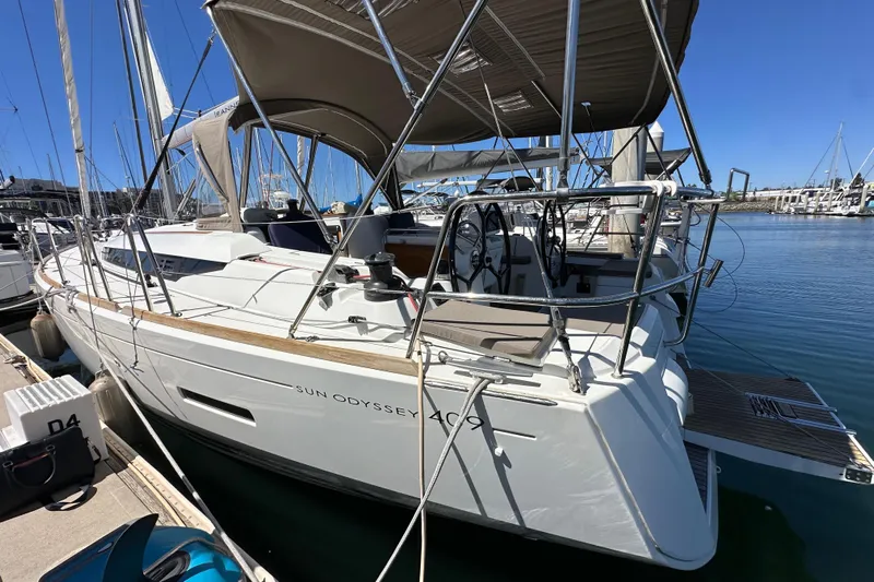 Jenni Yacht Photos Pics 2015 Jeanneau Sun Odyssey 409 yacht docked at marina, showcasing sleek design.