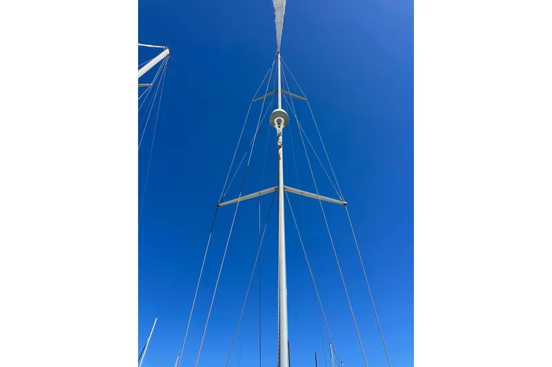 Jenni Yacht Photos Pics Mast of 2015 Jeanneau Sun Odyssey 409 sailboat against clear blue sky.