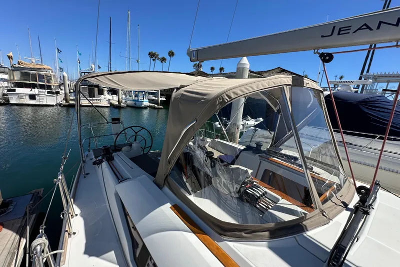 Jenni Yacht Photos Pics 2015 Jeanneau Sun Odyssey 409 sailboat docked in a marina under clear blue skies.