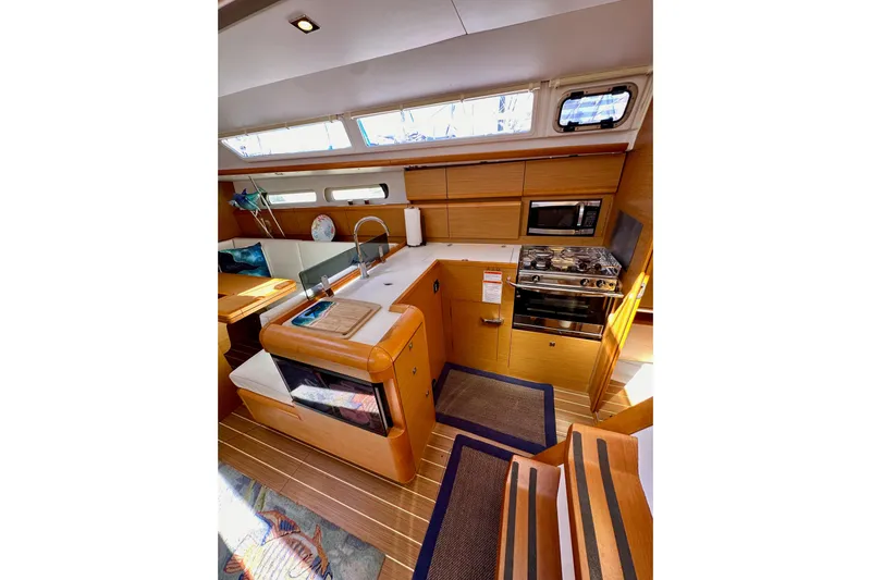 Jenni Yacht Photos Pics Interior of 2015 Jeanneau Sun Odyssey 409 yacht, featuring modern kitchen and seating area.