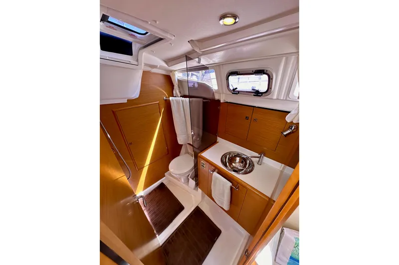 Jenni Yacht Photos Pics 2015 Jeanneau Sun Odyssey 409 yacht bathroom with wooden cabinetry and modern fixtures.
