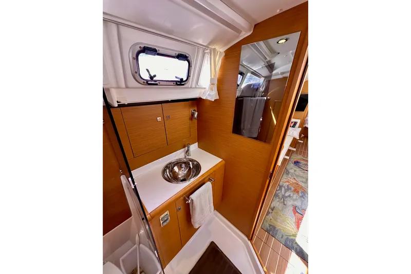 Jenni Yacht Photos Pics Interior of 2015 Jeanneau Sun Odyssey 409 yacht bathroom with sink and mirror.