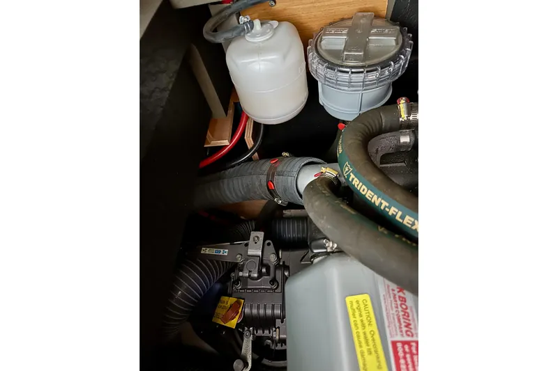 Jenni Yacht Photos Pics Engine compartment of 2015 Jeanneau Sun Odyssey 409 sailboat, showing hoses and components.