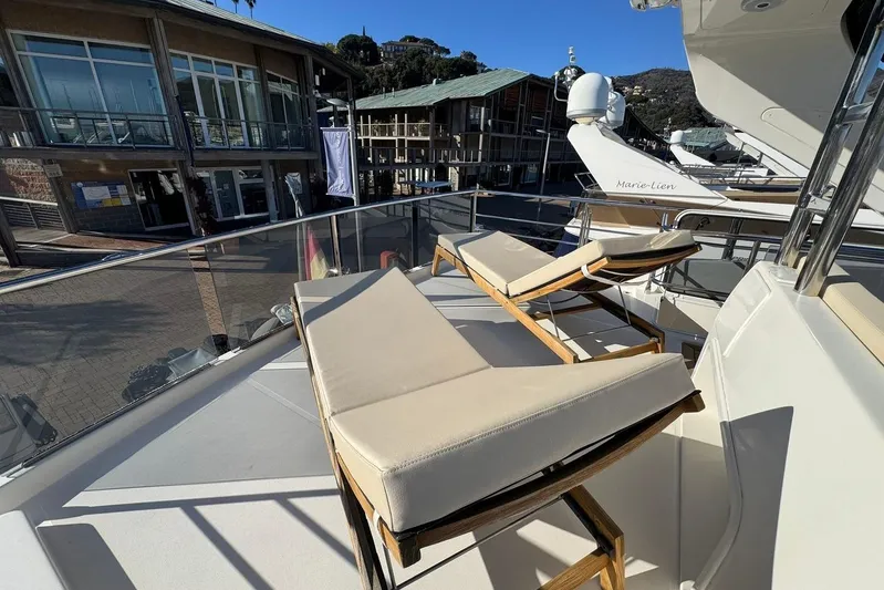  Yacht Photos Pics Sun loungers on the deck of a 2017 Absolute 60 Fly yacht, docked at a marina.