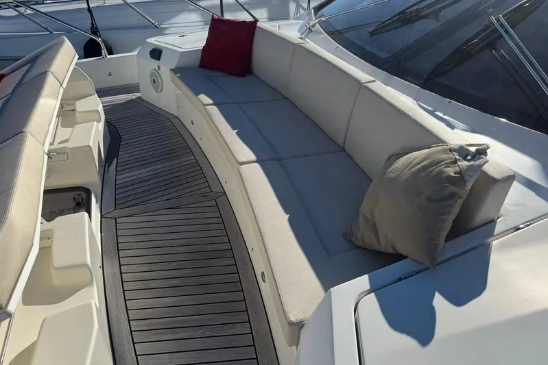  Yacht Photos Pics Luxurious seating area on 2017 Absolute 60 Fly yacht with cushions and wooden deck.