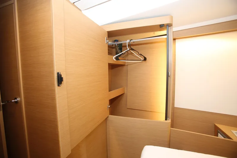 Valinore Yacht Photos Pics Interior of 2023 Jeanneau Sun Odyssey 490 yacht, featuring a wooden wardrobe with hangers.
