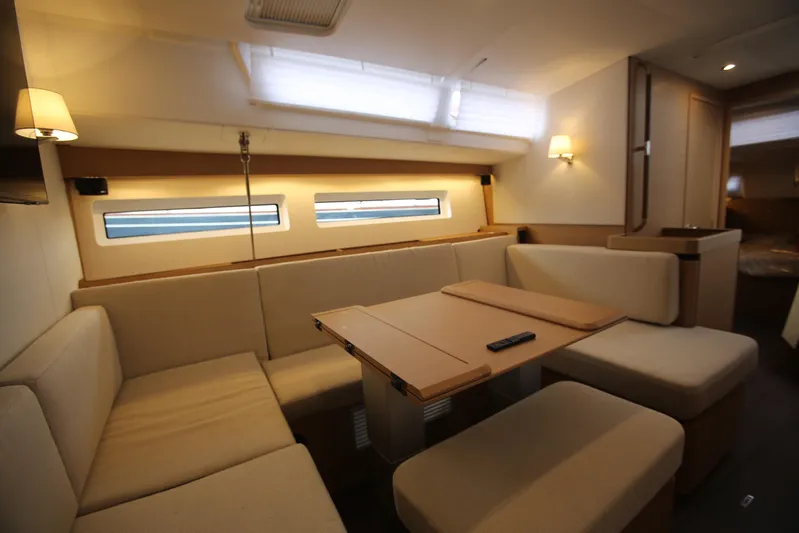 Valinore Yacht Photos Pics Interior of 2023 Jeanneau Sun Odyssey 490 yacht, featuring a cozy dining area with beige seating.