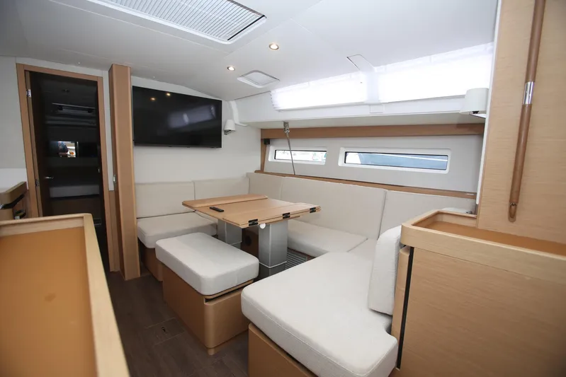 Valinore Yacht Photos Pics Interior of 2023 Jeanneau Sun Odyssey 490 yacht, featuring modern seating and a mounted TV.