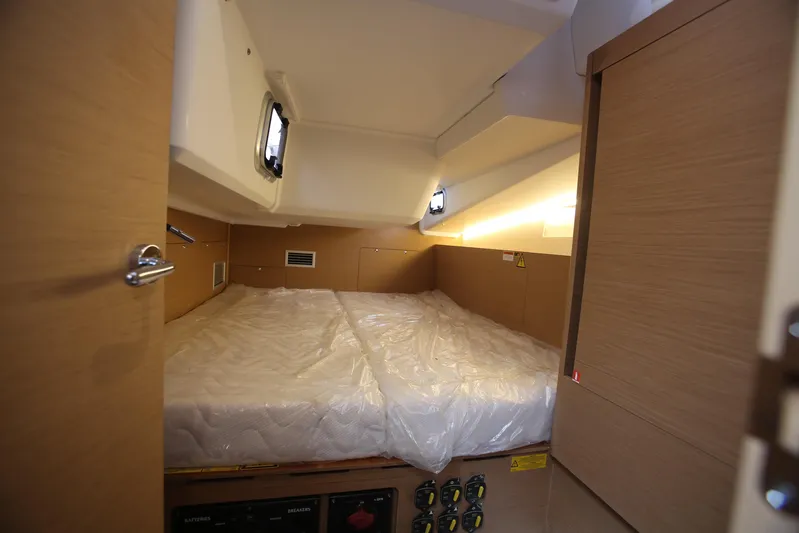 Valinore Yacht Photos Pics Cabin interior of 2023 Jeanneau Sun Odyssey 490 yacht with bed and wooden finish.