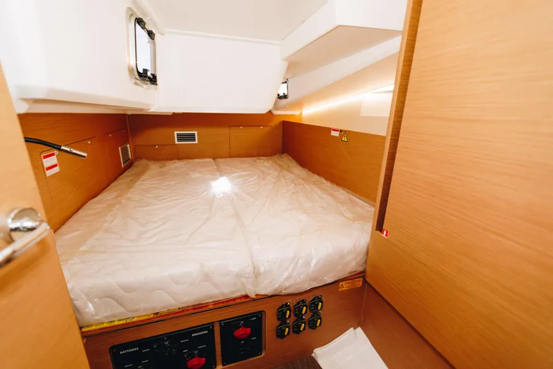 Valinore Yacht Photos Pics Cabin interior of 2023 Jeanneau Sun Odyssey 490 yacht, featuring a cozy bed and wooden finish.