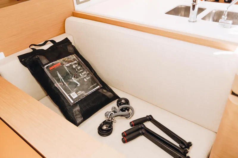 Valinore Yacht Photos Pics Jeanneau Sun Odyssey 490 interior with tools and accessories on a cushioned seat.