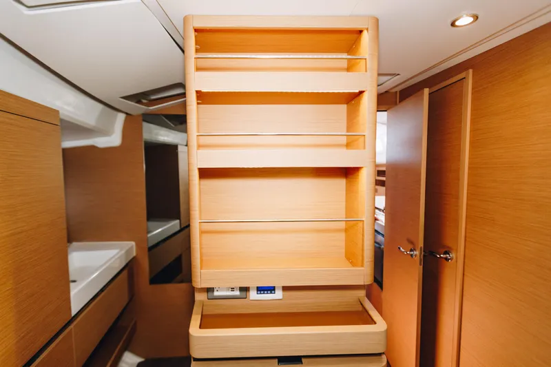 Valinore Yacht Photos Pics Interior of 2023 Jeanneau Sun Odyssey 490 yacht with wooden cabinetry and shelving.