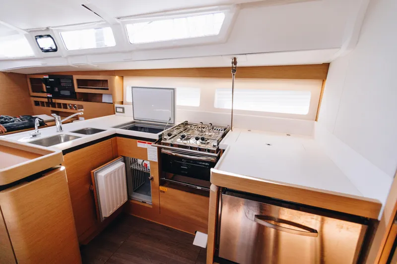 Valinore Yacht Photos Pics Modern kitchen interior of 2023 Jeanneau Sun Odyssey 490 yacht, featuring stove and sink.