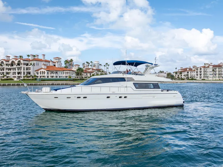 Bramamare Yacht Photos Pics Sanlorenzo 62 yacht from 1995 cruising near luxury waterfront homes.