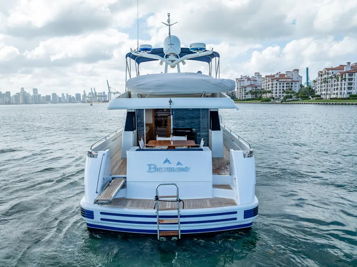 Bramamare Yacht Photos Pics Sanlorenzo 62 yacht from 1995 on water, city skyline in background.