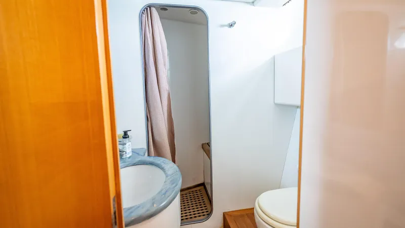 Bramamare Yacht Photos Pics Bathroom interior of 1995 Sanlorenzo 62 yacht with shower, sink, and toilet.