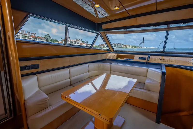 Bramamare Yacht Photos Pics Luxurious interior of 1995 Sanlorenzo 62 yacht with leather seating and wooden table.