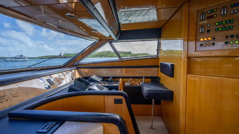 Bramamare Yacht Photos Pics Interior view of 1995 Sanlorenzo 62 yacht cockpit with control panels and seating.