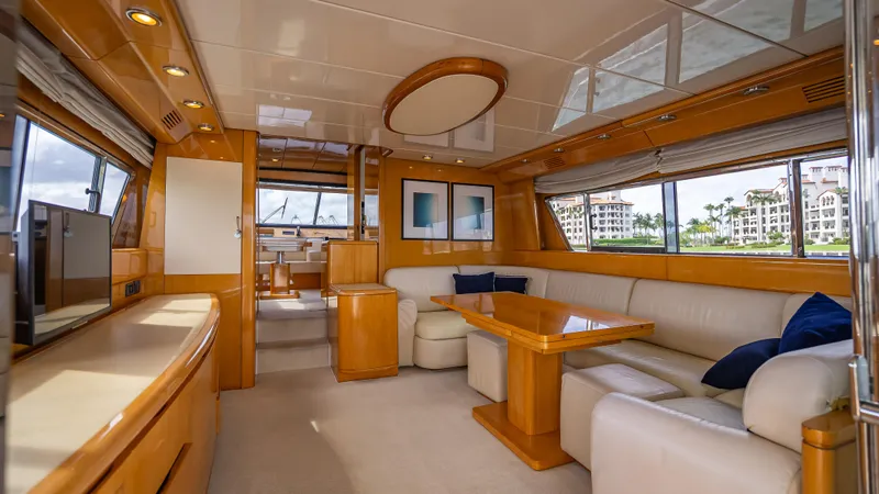 Bramamare Yacht Photos Pics Luxurious interior of a 1995 Sanlorenzo 62 yacht with elegant wood finishes and plush seating.