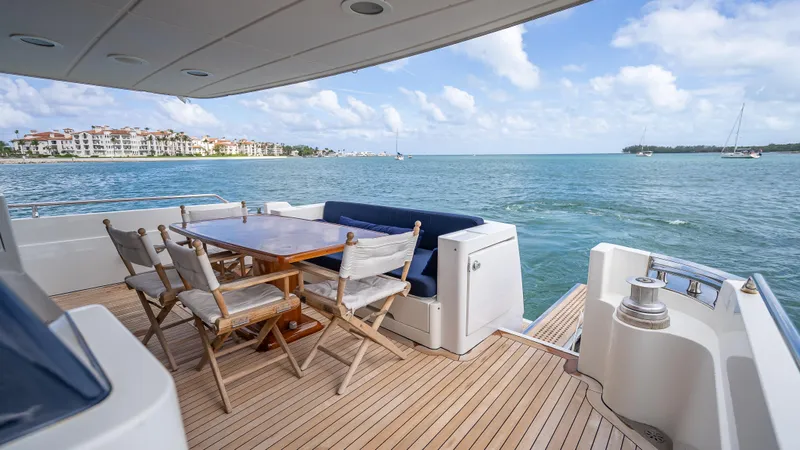 Bramamare Yacht Photos Pics Luxury Sanlorenzo 62 yacht deck with dining area, overlooking serene ocean view, 1995 model.