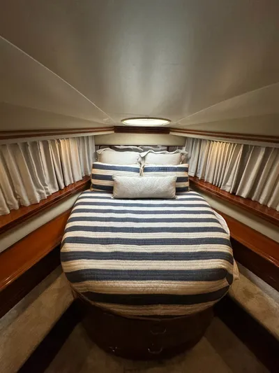 Cloud 9 Yacht Photos Pics Luxurious 2004 Carver 56 Voyager yacht bedroom with striped bedding and elegant curtains.