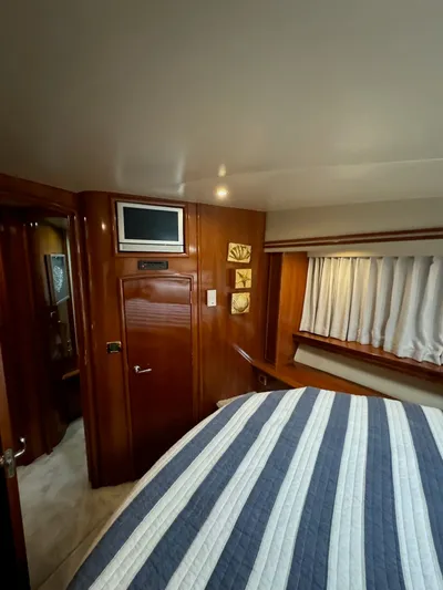 Cloud 9 Yacht Photos Pics Interior of 2004 Carver 56 Voyager yacht, featuring wood paneling and a cozy bedroom.