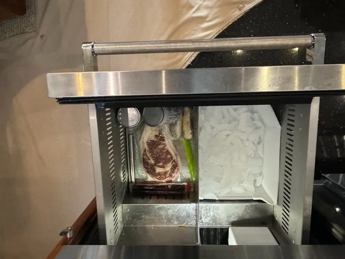 Cloud 9 Yacht Photos Pics Open refrigerator drawer with steak, ice, and canned drinks on a Carver 56 Voyager yacht.