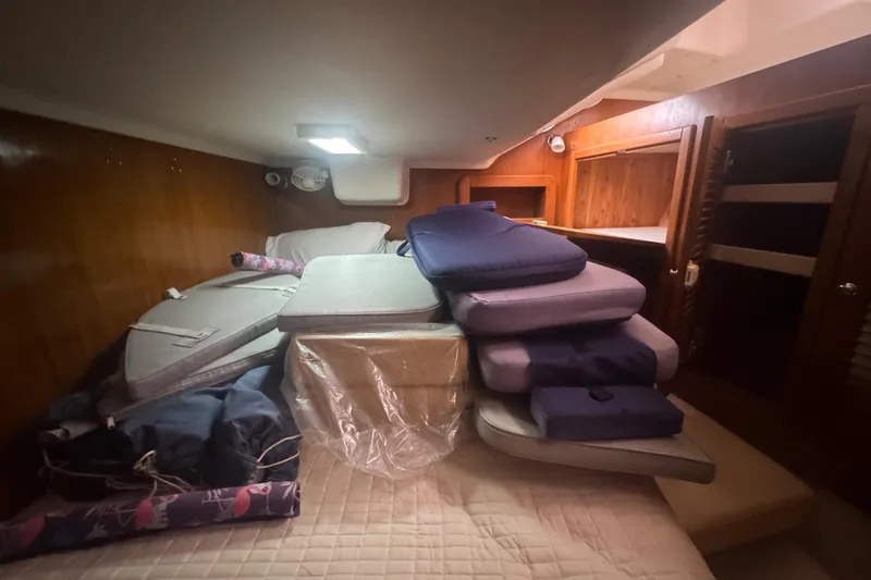 True Love Yacht Photos Pics Interior cabin of 2005 Catalina Morgan 440 DS with stacked cushions and wooden paneling.