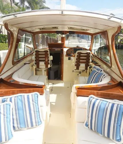  Yacht Photos Pics Interior of 2013 Hinckley Talaria 34 boat with striped cushions and wooden accents.