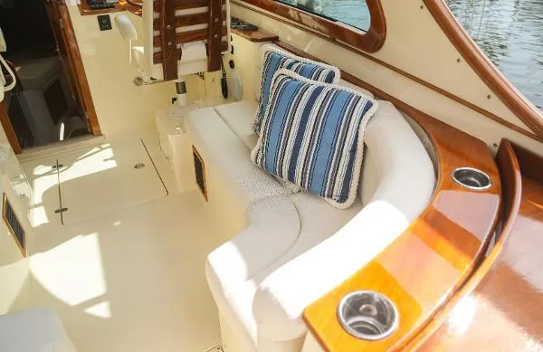  Yacht Photos Pics Luxurious interior of 2013 Hinckley Talaria 34 yacht with plush seating and striped cushions.