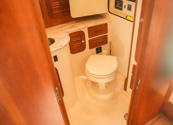  Yacht Photos Pics 2013 Hinckley Talaria 34 yacht bathroom with wooden cabinetry and modern fixtures.