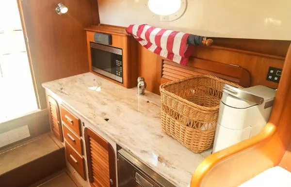 Yacht Photos Pics Hinckley Talaria 34 yacht kitchen interior with microwave, wicker basket, and striped towel, 2013 model.