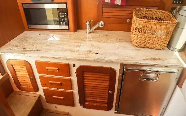  Yacht Photos Pics Hinckley Talaria 34 yacht kitchen with wooden cabinets, microwave, and countertop, 2013 model.
