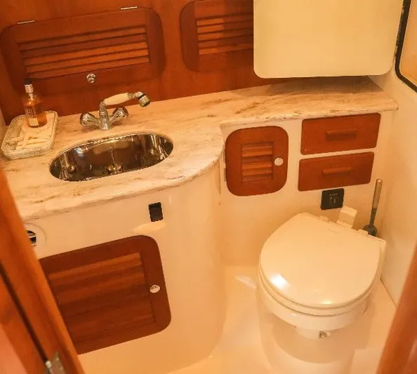  Yacht Photos Pics 2013 Hinckley Talaria 34 yacht bathroom with wooden cabinetry and marble countertop.