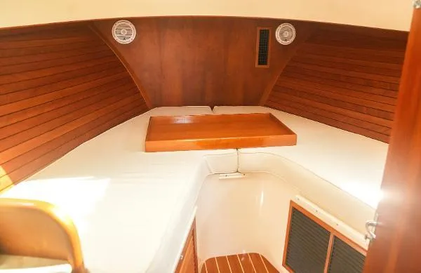  Yacht Photos Pics 2013 Hinckley Talaria 34 cabin interior with wooden paneling and white bedding.